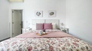 A bedroom with a bed, two nightstands, a door, and two wall-mounted pictures. - Villa Barranco de los Cernícalos - 2-Bedroom Cabin (Vegas, Las (Valsequillo))