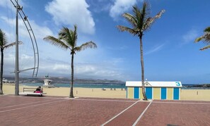 Un passeig marítim amb palmeres, una torre de socorristes i un edifici marcat amb el número 3.