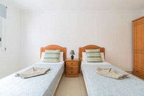 A twin bedroom with two beds, a nightstand, and a wardrobe. - Sagasta Canteras Apartment (Palmas De Gran Canaria, Las)