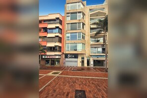 Un edifici d'altes plantes amb comerços a la planta baixa, com ara un restaurant i una botiga.