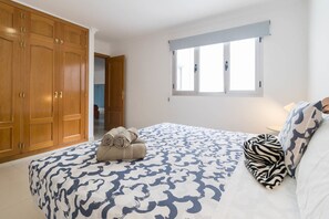 A bedroom with a large bed, a wardrobe, a window, and a view of another room. - Sagasta Canteras Apartment (Palmas De Gran Canaria, Las)
