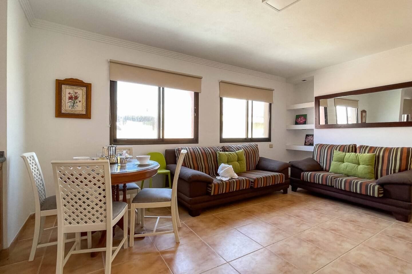 Ein Wohnzimmer mit einem Esstisch, zwei Sofas und einem Sessel.