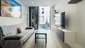 A modern living room with a sofa, a coffee table, and a TV on a stand. - Guanarteme Vista Surf, Las Canteras 2 (Palmas De Gran Canaria, Las)