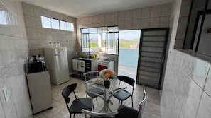 Cocina compacta con comedor, refrigerador, estufa y ventana con vistas.