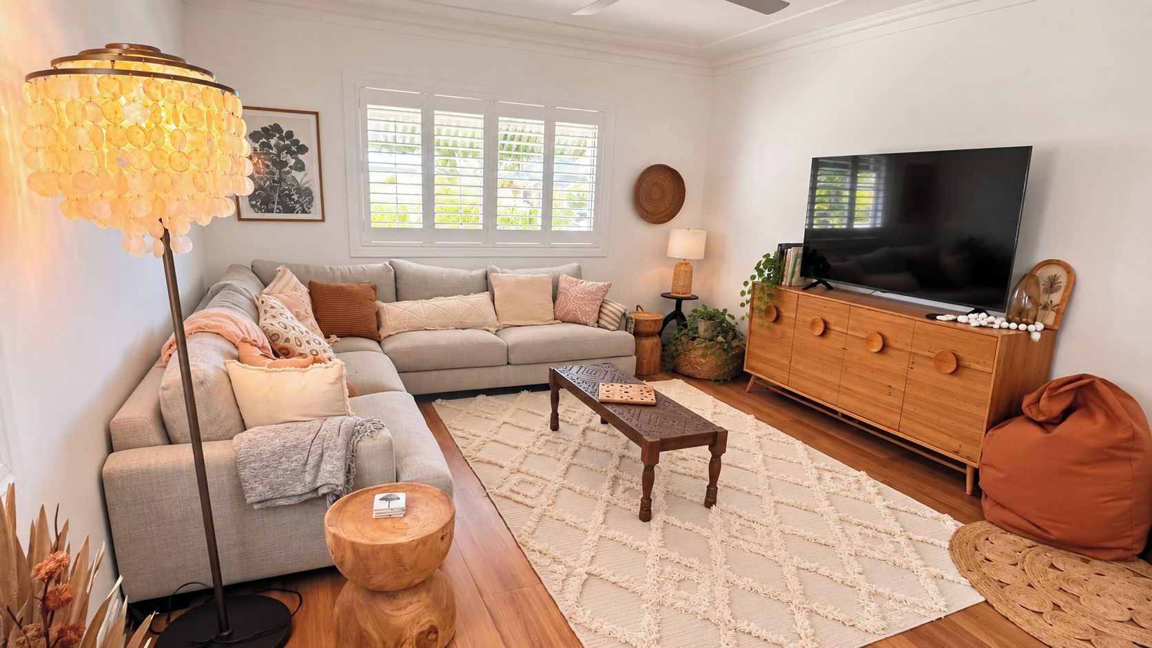A living room with a sofa, coffee table, TV stand, and decorative items.