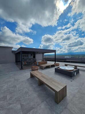 A rooftop terrace with a dining area, seating arrangements, and a view of the landscape. - New Listing (Montenegro)
