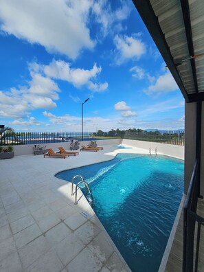 A swimming pool with lounge chairs and a clear sky. - New Listing (Montenegro)