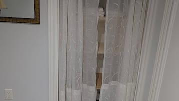 A room with a white door, a mirror on the wall, and a carpeted floor.