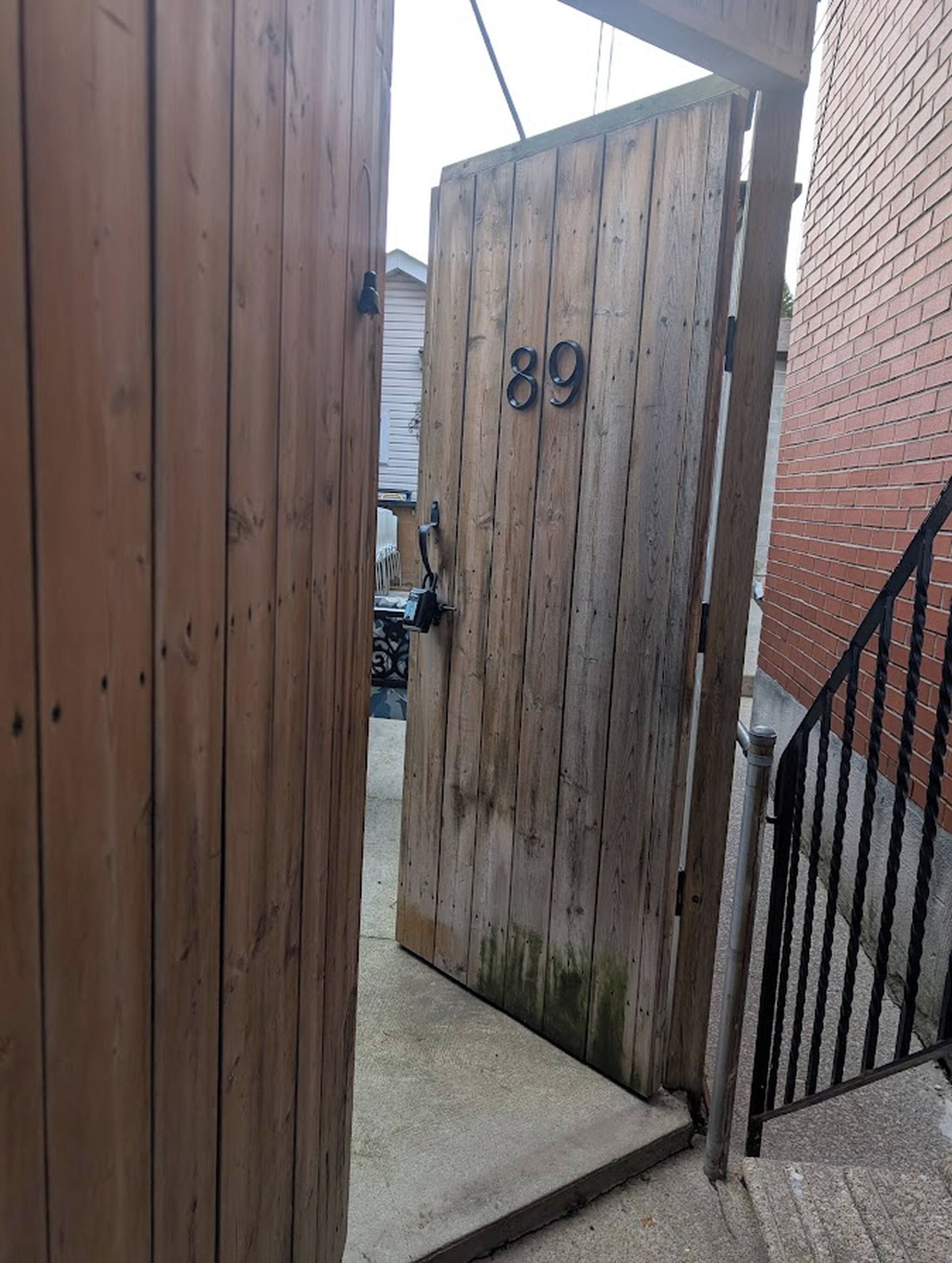 A wooden gate with the number 89, leading to a concrete staircase.