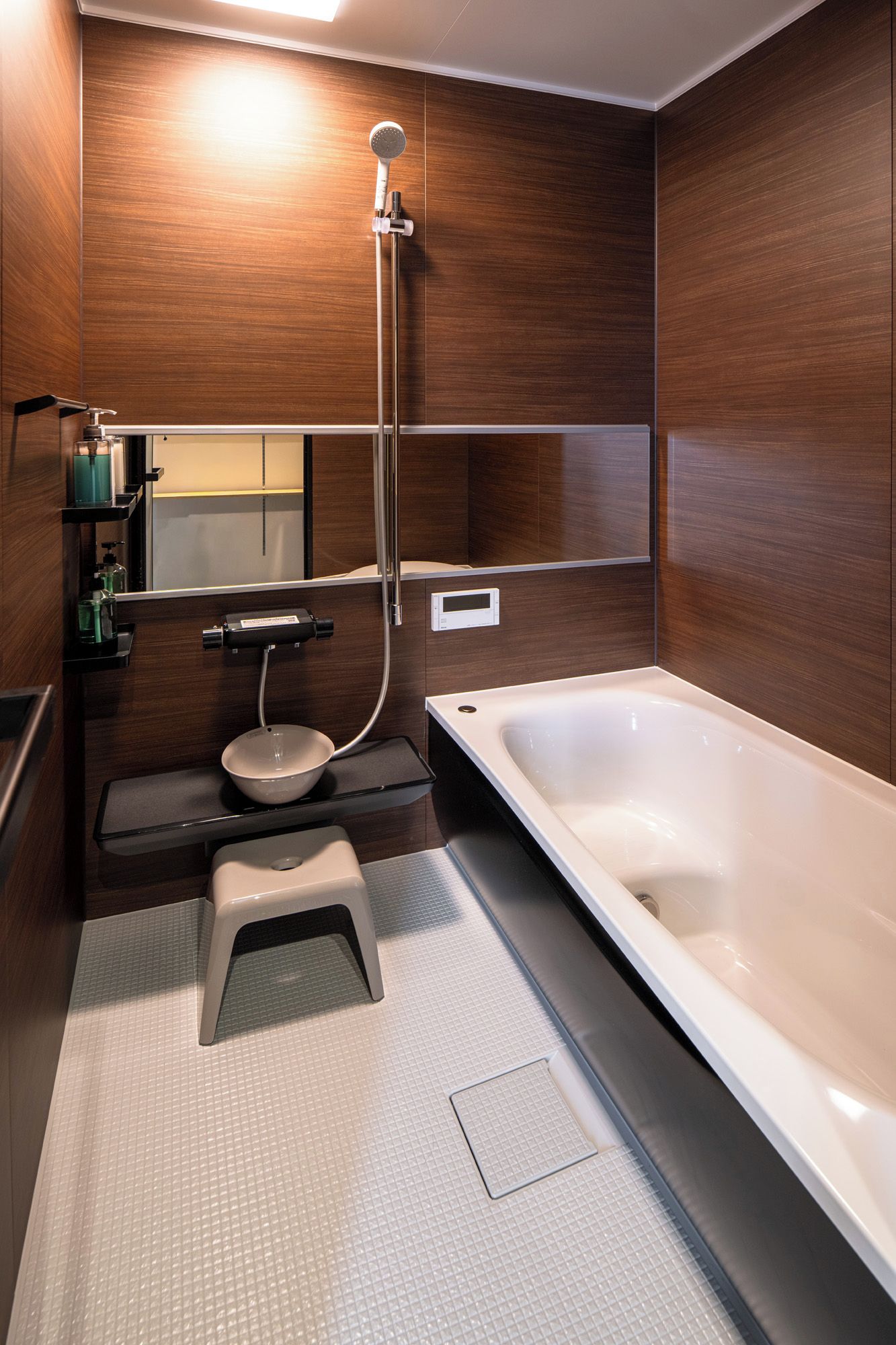 A modern bathroom with a bathtub, shower, and toilet.