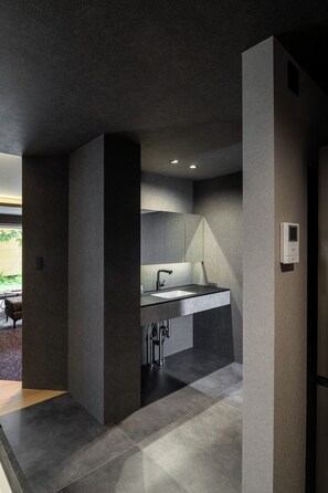 Una cocina moderna con una isla central, electrodomésticos integrados y una lámpara empotrada en el techo.