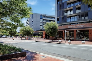 A street view with a modern building featuring a storefront named 'eyre st. market'. - Stylish 1-Bed Apartment with Outdoor Space (Kingston)