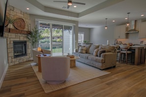 A modern kitchen with a dining area, a fireplace, and a large sliding glass door leading to a patio.