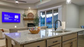 A modern kitchen with granite countertops, a built-in dishwasher, and a large island with a sink.