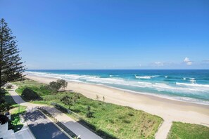 A coastal road leading to a beach with waves crashing onto the shore. - The Esplanade, Palm Beach (Palm Beach)
