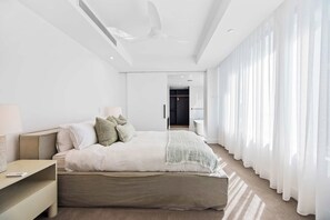 A modern bedroom with a large bed, a bedside table, and a walk-in closet. - The Esplanade, Palm Beach (Palm Beach)