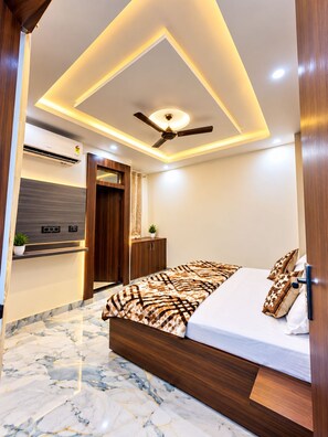 Un dormitorio moderno con cama, ventilador de techo y suelo de mármol.