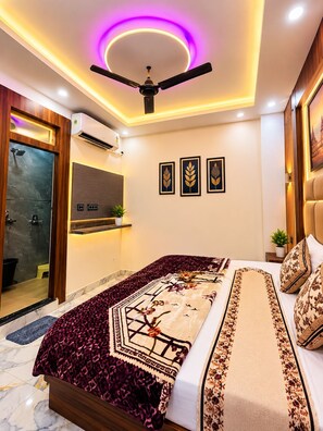 Un dormitorio moderno con cama, ventilador de techo, equipo de aire acondicionado y una obra de arte enmarcada en la pared.