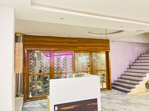 Un interior moderno con una escalera, un ventanal con vistas al exterior y un panel de madera en la pared.