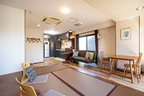 A modern interior with a dining area, sofa, and kitchen.