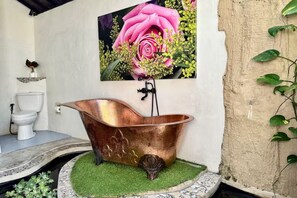 A bathroom with a copper bathtub, a white toilet, and a wall-mounted sink. - Luxury Villa Near Ubud with Private Gym & Copper Bathtub_PARVATI (Kecamatan Ubud)