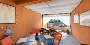 A dining area with a table set for four, a view of the outdoors, and a decorative map on the wall. - Holiday Apartment My Adria A3 (Vantačići)