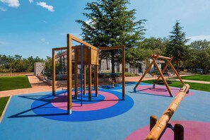 A playground with a climbing structure, swings, and a seesaw. - Mobile home with air conditioning, terrace and pool (Umag)