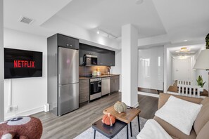 A modern apartment with a kitchen, living area, and a TV mounted on the wall. - Scarborough Skyline Retreat | 2Bed & Balcony (Toronto)