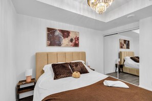 A modern bedroom with a large bed, a nightstand, a bedside lamp, and a mirror. - Scarborough Skyline Retreat | 2Bed & Balcony (Toronto)