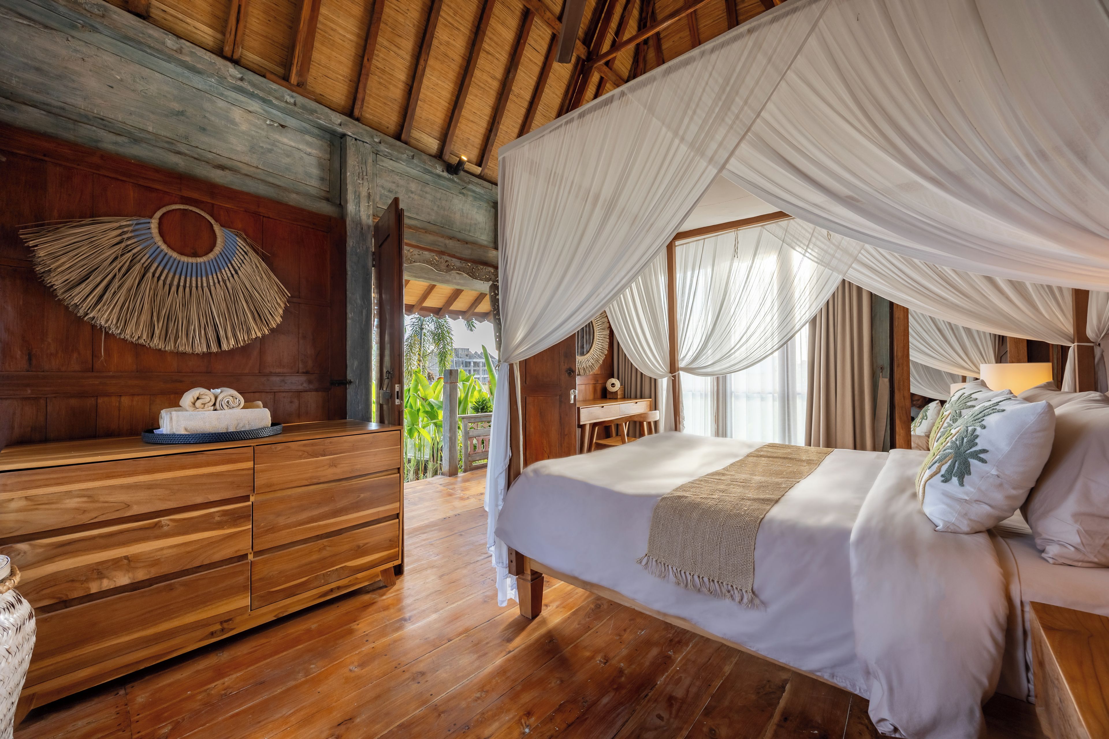 Una habitación de madera con una cama, un aparador de madera y un tapiz hecho a mano.