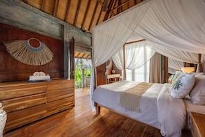 Una habitación de madera con una cama, un aparador de madera y un tapiz hecho a mano.