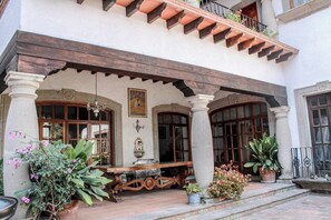 Un bâtiment de style traditionnel doté d’un patio couvert, de colonnes et de plantes en pot.
