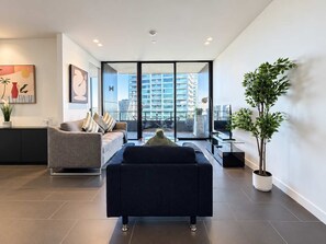 Ein modernes Wohnzimmer mit einer Couch, einem Couchtisch und einer Zimmerpflanze.