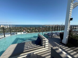 Une piscine à débordement située sur le toit, offrant une vue sur la ville et l’océan.