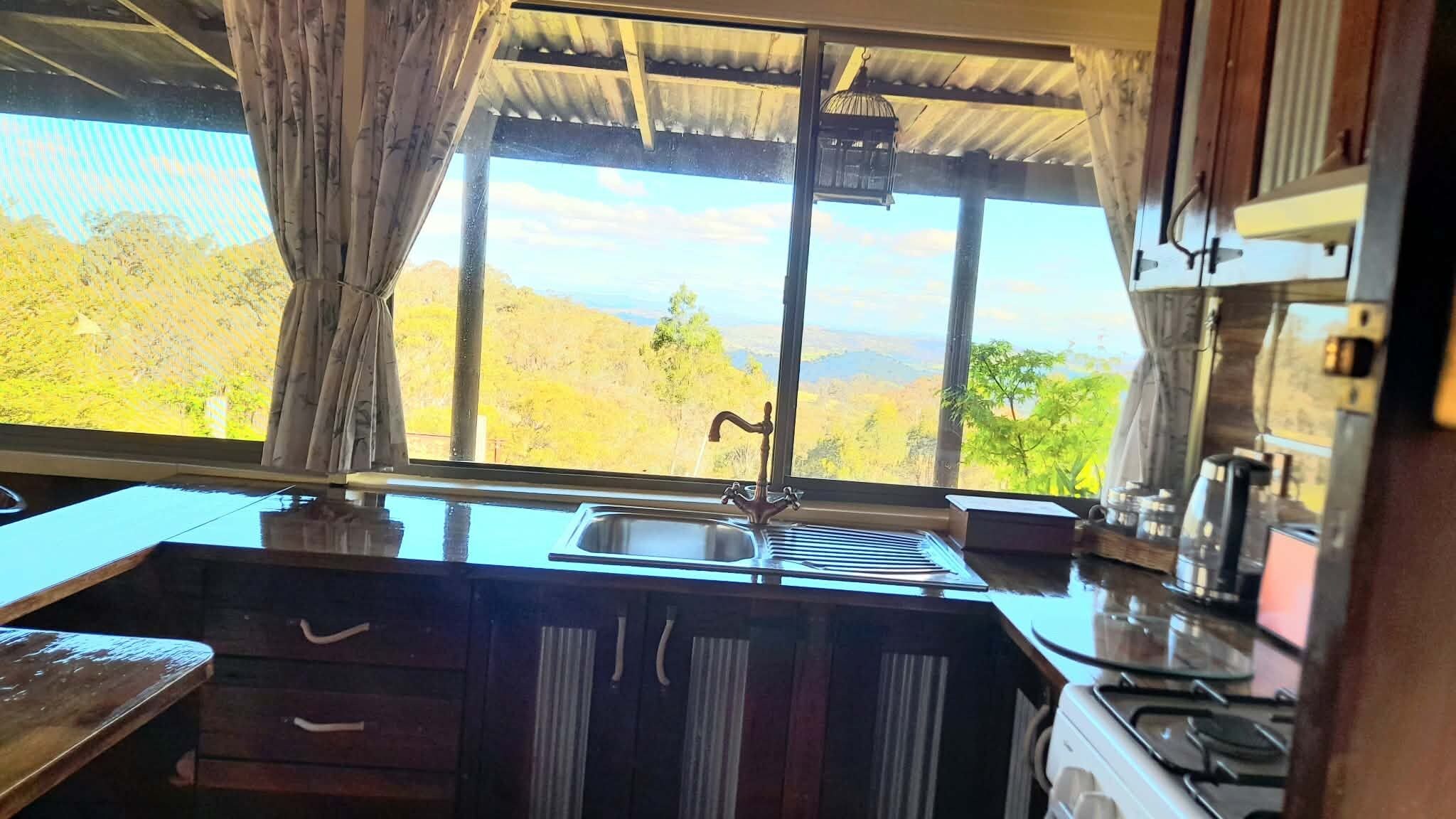 A kitchen with a window, a sink, and a stove.