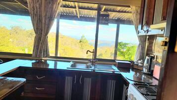 A kitchen with a window, a sink, and a stove.