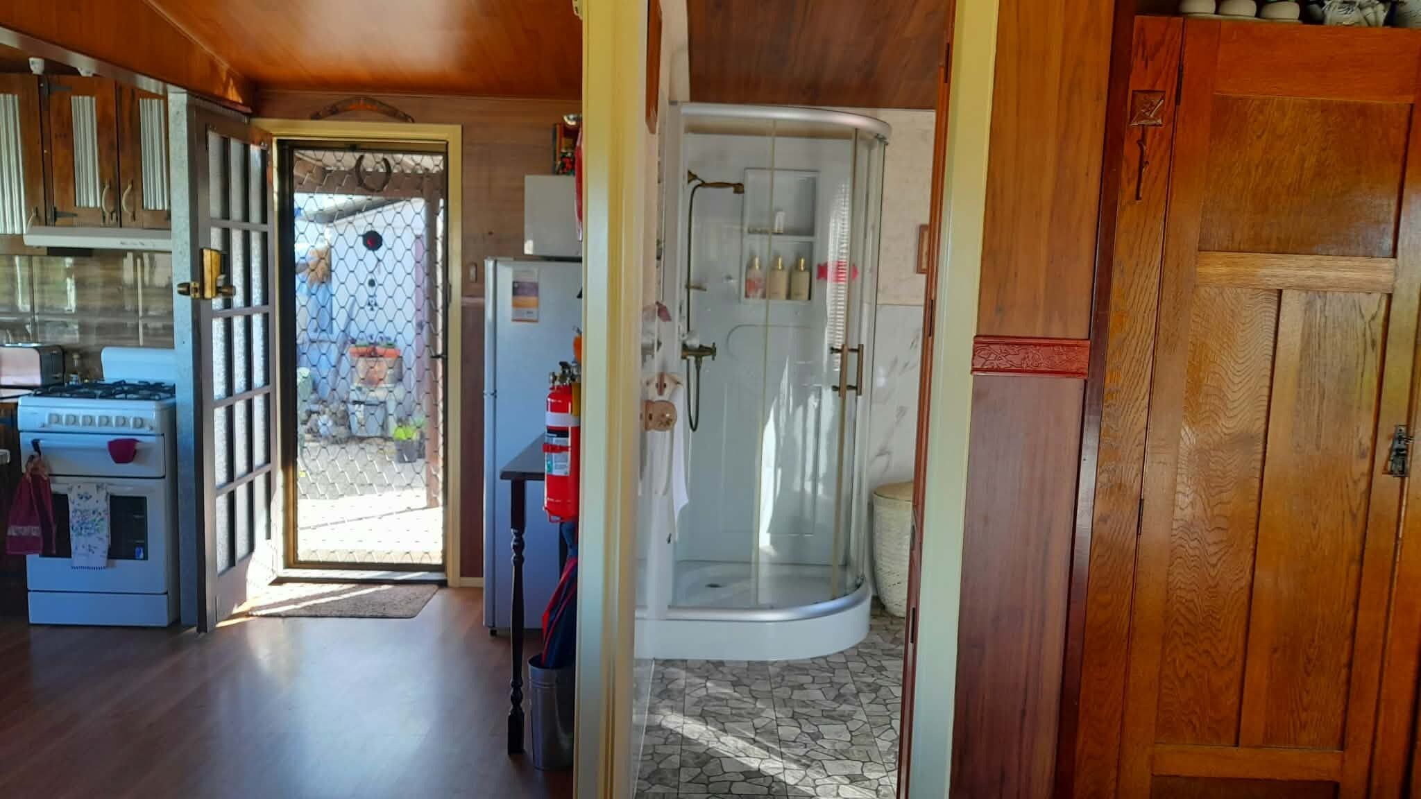 A kitchen with a stove, a refrigerator, and a wooden cabinet.
