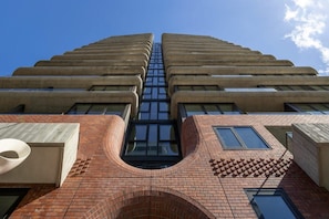 Un bâtiment moderne à la façade symétrique, doté de grandes fenêtres et d’une section centrale en verre.