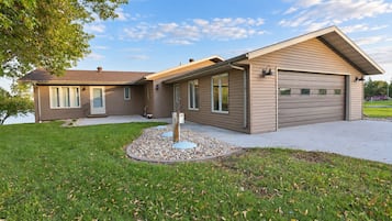 A two-story house with a garage, a covered patio, and a landscaped front yard.