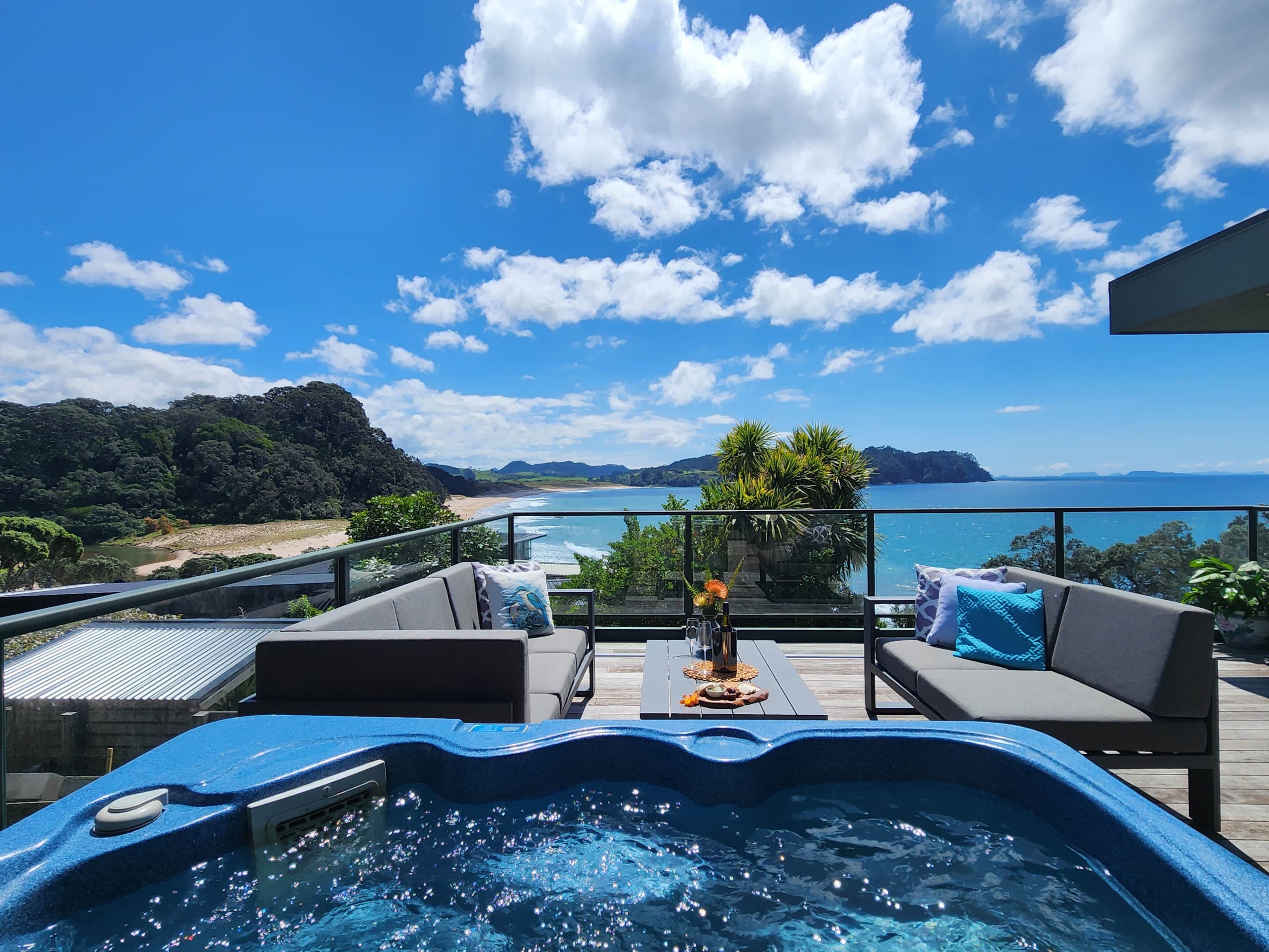 A hot tub with a view of the sea and mountains.