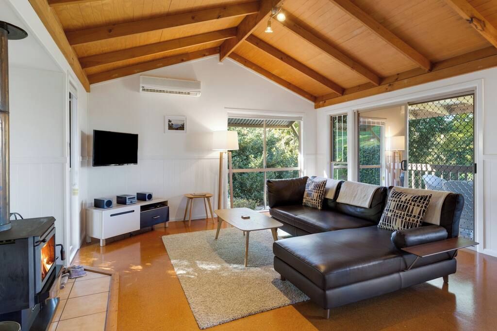 Un salon moderne avec une cheminée, un canapé, une table basse et un téléviseur.