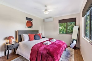 A bedroom with a bed, a nightstand, a mirror, and a window. - Yume House Stylish Country Escape 1 Bedroom (Ravensbourne)