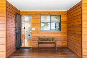 A wooden interior with a bench, a door, and a window. - Stella Luna - Luxury Chalet 1 Bedroom (Ravensbourne)