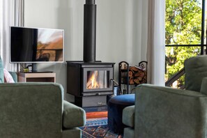 A living room with a modern fireplace, a flat-screen TV, and comfortable seating. - Havenwood Chalet 1 Bedroom (Ravensbourne)