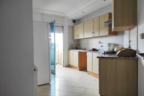 A kitchen with light-colored cabinets, a countertop, and a microwave. - Urban Flat near Lake (Tunis)