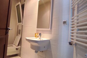 A bathroom with a white sink, a toilet, and a mirror. - Urban Flat near Lake (Tunis)