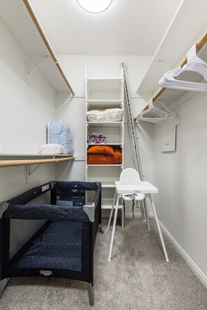 A compact storage room with shelves, a ladder, a folding chair, and a crib. - Charming 2-bedroom apartment with pool, gym and free parking in Marina del Rey! (Marina del Rey)
