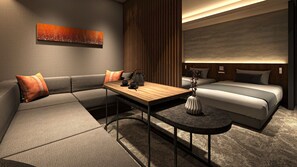 Ein modernes Hotelzimmer mit einer Couch, einem Esstisch, einem kleinen Tisch mit einer Vase und einem Bett mit Kopfteil.
