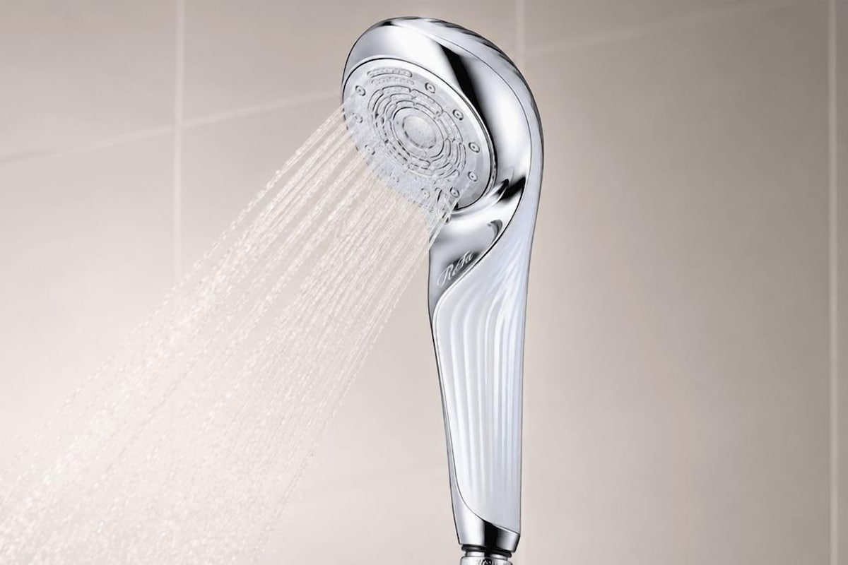 A chrome showerhead with water flowing from it.