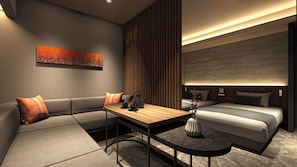 A modern hotel room with a sofa, a small table, a bed, and a decorative wall piece.
